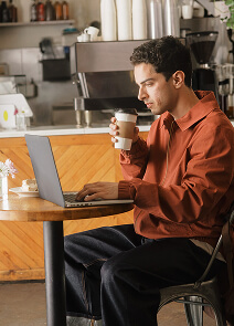 Homem a trabalhar e a tomar café