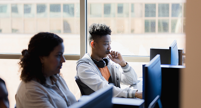 Two people using computers
